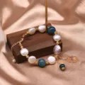 Natürliche Süßwasserperle und blauer Edelstein Armband Detail mit goldenem Metall und Anhänger. - Kyanit Kreuz Stil