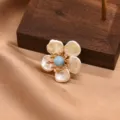 Baroque pearl flower brooch with blue center stone and gold finish, elegant jewelry accessory. - Aquamarine