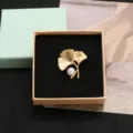 Elegant gold ginkgo leaf brooch featuring a lustrous white pearl, perfect jewelry accessory. - Ginkgo Leaf Shape