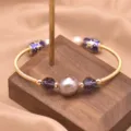 Elegantes Naturperlenarmband mit lila Kristallperlen und retro goldem Metalldraht-Design. - Lila Perle Kristall Cloisonne Armreif / Gold