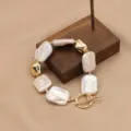Barocke Süßwasserperlen Armband mit goldfarbenen Metallelementen und stilvollem Knebelverschluss. - Weißes quadratisches Set Armband