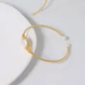 Elegantes offenes Armband aus goldenem Draht mit echter Naturperle für Damen Schmuck Stil - Auge Motiv Drahtumwickelt Armreif
