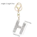 Nahaufnahme Detailaufnahme eines glitzernden Strass-Buchstaben-H-Schlüsselanhängers in Gold. - Buchstabe H / Weißer Strass