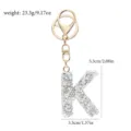 Nahaufnahme des glitzernden Strass-Buchstaben-K-Schlüsselanhängers mit goldener Hardware. - Buchstabe K / Weißer Strass