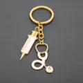 Cute medical keychain featuring gold syringe and stethoscope charms, perfect for nurses and doctors. - Medical Stethoscope Keychain (G-686)