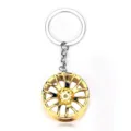 Gold car wheel rim keychain, miniature alloy tire keyring, stylish automotive accessory pendant. - Gold