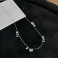 Détail en gros plan du collier pendentif goutte d'eau scintillant sur fond noir élégant. - Or blanc