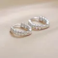 Detalle de cerca de pendientes de aro de plata S999 con moneda de cobre y textura de lujo. - Plata 925 / Plata