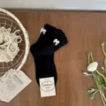 Black mid-calf socks for women featuring sweet white bow accents and delicate ruffled cuffs. - One Size / Black