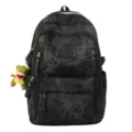 Close-up detail of the black nylon school backpack featuring trendy embroidered letters. - Black