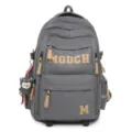Grey grid student backpack detail view, featuring beige leather letter patches and zipper pulls. - Gray