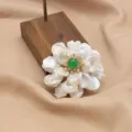 Baroque pearl flower brooch with green gemstone center, elegant jewelry accessory for women. - Three-Layer Petal and Pearl Brooch with Green Stone Center