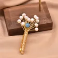 Elegant freshwater pearl bouquet brooch with gold wire wrapped design and chic blue bead accent. - Light Blue Pearl Bouquet Brooch