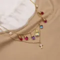 Collier multicouche doré avec des pendentifs colorés, une perle et un pendentif croix. - Croix Multicolore à Étages Détachable / 52cm