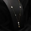 Long collier de perles baroques élégant avec chaînes plaquées or et anneaux métalliques uniques. - Sautoir asymétrique couleur contrastée