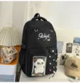 Detail of black school backpack with embroidery text, clear front pocket and plush toy. - With Pendant / Black