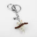 Portachiavi gatto in resina bianca su ramo marrone con campanellino d'argento. - Portachiavi Gatto dei Cartoni Animati (G-1389)