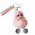 Close-up of a cute plush doll keychain with pink fur pom-pom and leather strap - Pink