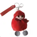 Detail view of a cute red plush doll keychain with a knit hat and ribbon bow decoration - Red