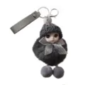 Detailed view of a cute grey plush doll keychain featuring a knitted hat and silver bow - Gray