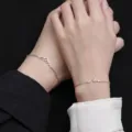 Detaillierte Nahaufnahme der passenden Berg und Welle Partner Armbänder an den Händen. - Berg Design Armband / Weißgold