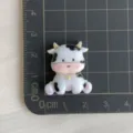 Detailopname van een schattige koe harsbedel, perfect voor telefoonhoesjes en haarspelden. - 4 Stuks/Pak / Zittende Koe