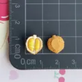 Primo piano di ciondoli durian in resina in miniatura con texture e dimensioni su griglia. - Durian Giallo (13)