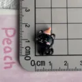 Close-up detail of cute mini black cat resin charm with party hat for DIY crafts. - Black Cat (07)