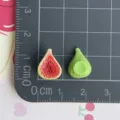 Dettaglio ravvicinato di ciondoli di fichi in resina in miniatura su tappetino a griglia. - Fico (06)