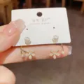 Primer plano de los detalles de pendientes de perlas florales, circón brillante de doble cara. - Plata 925 / Dorado