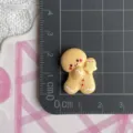 Resin gingerbread man charm detail view showing exact size on grid mat for DIY crafts. - Large-Star Gingerbread Man (F061)