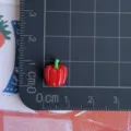 Dettaglio del ciondolo in resina a peperoncino rosso, ideale per piccoli lavori e nail art. - Modello di Peperone Rosso