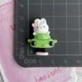 Close-up detail of a cute resin rabbit car charm, perfect for DIY phone cases and hair clips. - Rabbit in Green Rocking Car