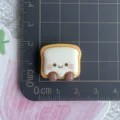 Resin bread cabochon detail view, cute smiley toast face design for DIY phone case craft accessories. - Smiling Toast Bread