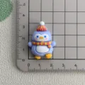 Cute penguin resin cabochon detail view showing size measurement on grid mat for DIY crafts. - Blue Penguin with Hat
