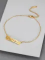 Close-up detail of golden titanium steel anklet featuring Taurus in Old English font - Taurus
