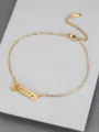 Macro detail of gold Pisces zodiac anklet in Old English font on textured gray surface - Pisces