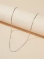 Close-up van een minimalistische zilveren titaniumstalen ketting op een beige achtergrond - Zilver