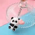 Leuke tekenfilm panda sleutelhanger met roze hart ballon, zachte rubberen sleutelhanger cadeau. - Stijl 5 (Hart Vasthoudend)