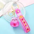 Cute quicksand lucky cat keychain pink wristband metal ring acrylic oil-filled car pendant - Purple