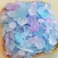 Vista dettagliata di ciondoli in resina con farfalle e rose smerigliate miste in blu pastello. - Serie Blu Smerigliata