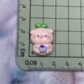 Close-up detail shot of the cute pink pig resin charm with blueberry, showing exact size. - Full Body Pig Holding Blueberry