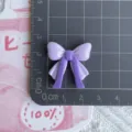 Glossy dual-color ribbon bow resin charm for DIY phone case and hair accessories detail view - Purple