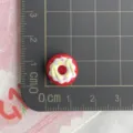 Primo piano del ciondolo a ciambella in resina rossa, dettaglio patch artigianale e misura. - Ciambella Rotonda Rossa / Confezione Mini