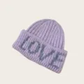 Detail shot of a lavender knitted beanie featuring a grey LOVE letter knit design on the brim. - One Size / Taro Purple