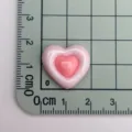 Primo piano dettaglio di patch cabochon in resina cuore rosa lucido bicolore. - Rosa