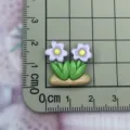 Resin flower cabochon detail view showing size on grid mat for DIY crafts and phone cases. - Double Flower Shape / Purple