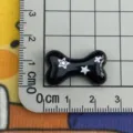 Pendentif en résine os noir avec un joli design d'étoiles blanches et roses pour déco téléphone. - Os Noir