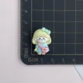 Gros plan détail d'un accessoire cabochon en résine de fille de dessin animé avec sac ours. - Cheveux Beige