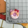 Primo piano di grazioso ciondolo ciambella coniglio in resina, perfetto per mollette e cover. - Ciambella Orso